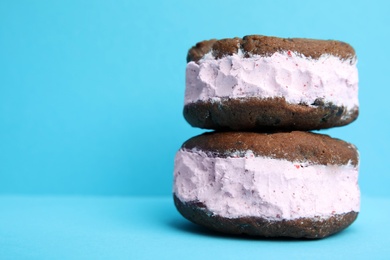 Photo of Sweet delicious ice cream cookie sandwiches on color background, closeup. Space for text