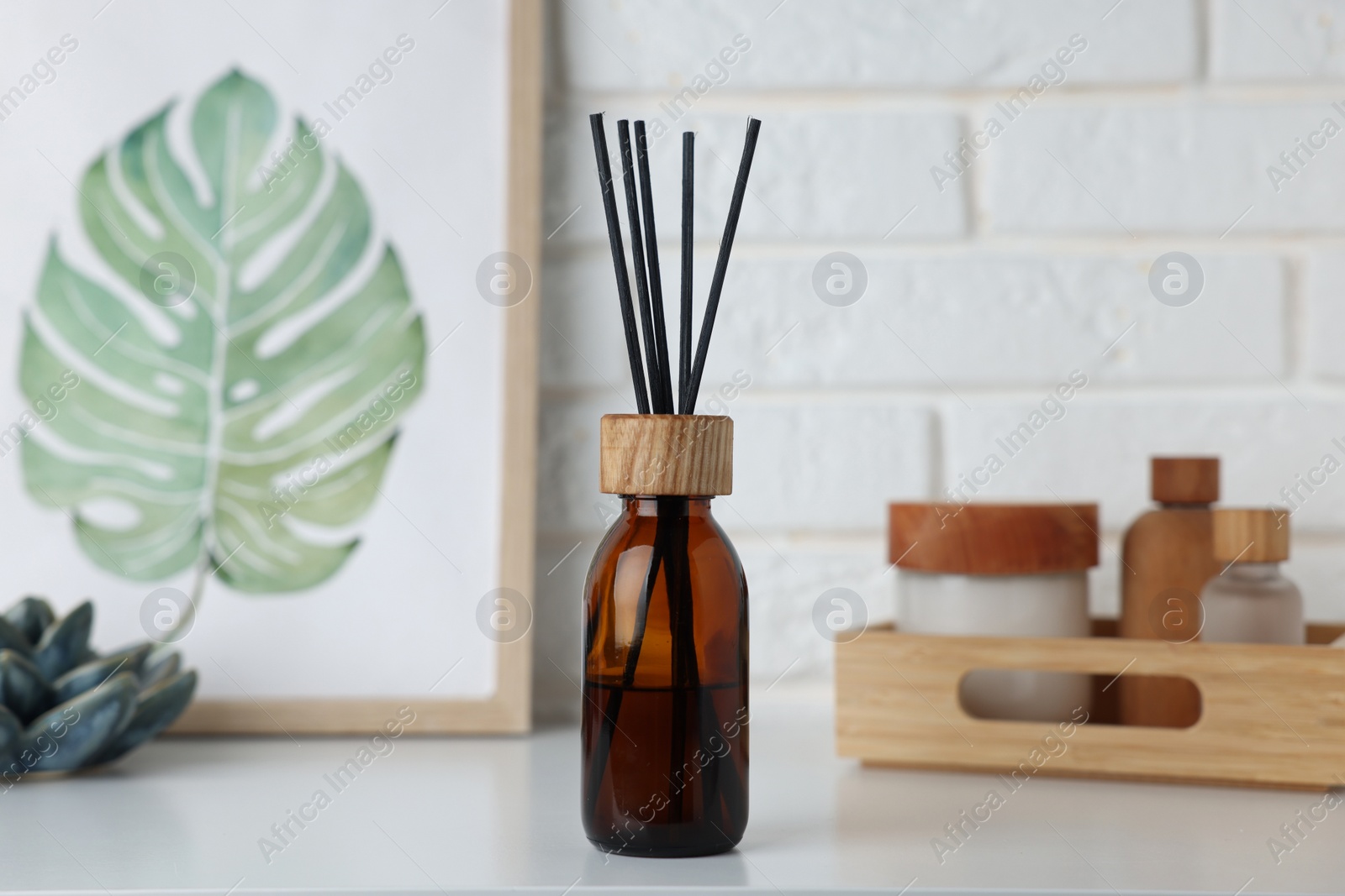 Photo of Air reed freshener, decor and cosmetic products on white table indoors