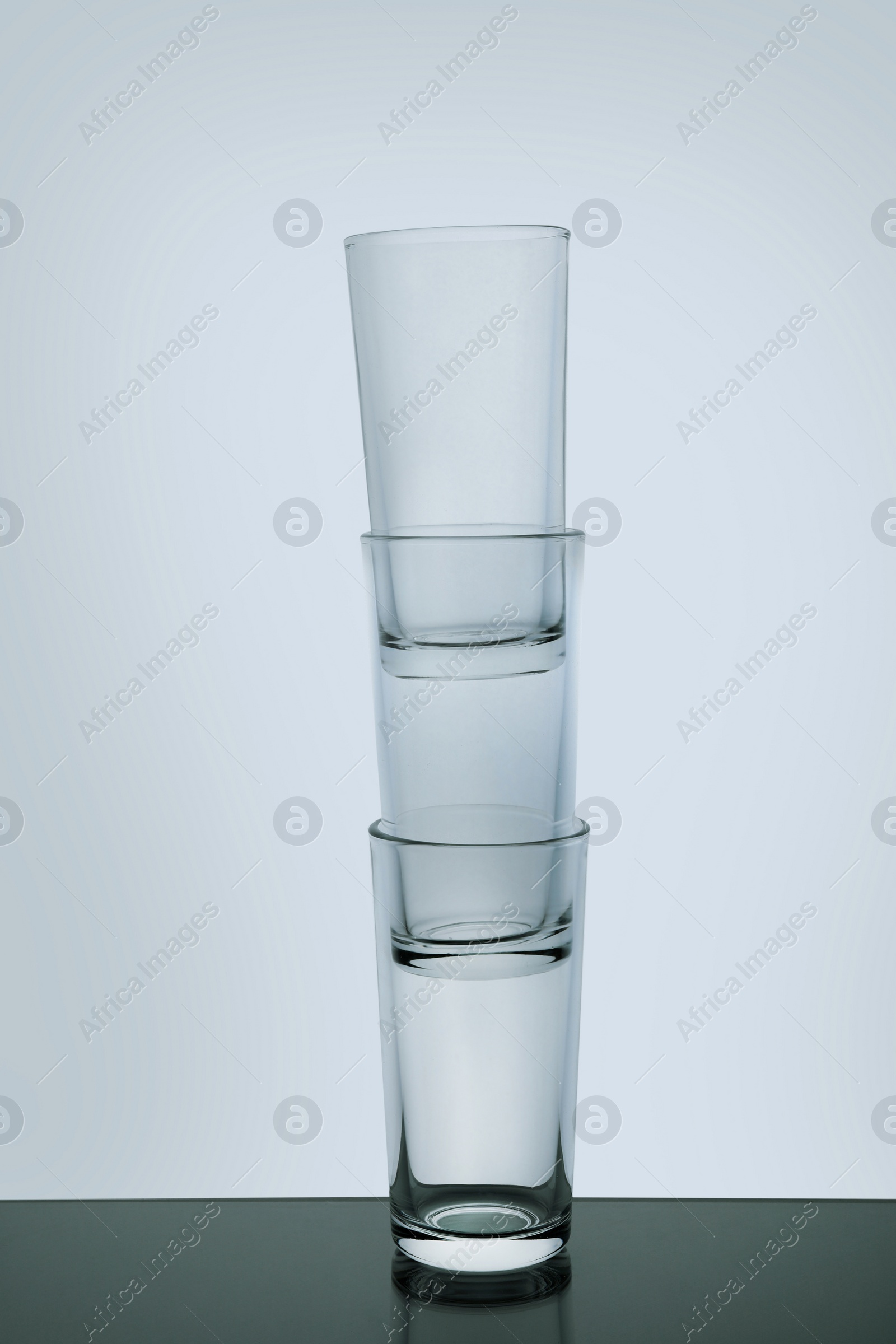 Photo of Stack of empty shooter glasses on white background