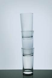 Stack of empty shooter glasses on white background