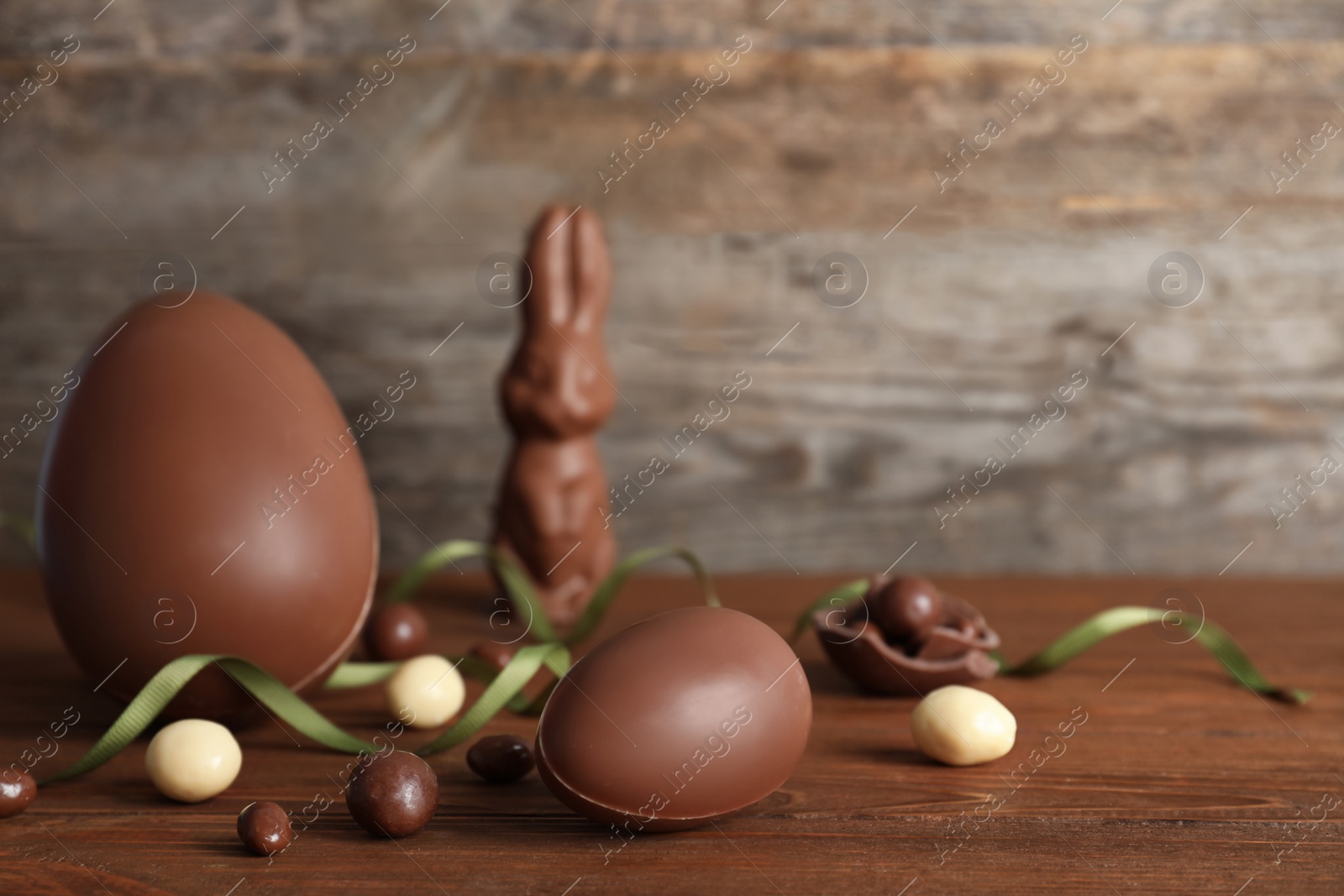 Photo of Beautiful composition with chocolate Easter eggs on wooden table. Space for text