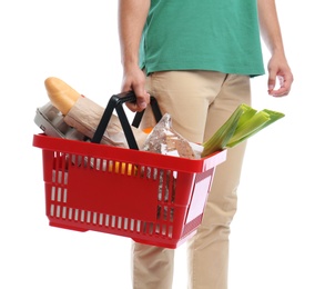 Young man with shopping basket full of products isolated on white, closeup