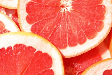 Photo of Many slices of fresh ripe grapefruits as background, closeup