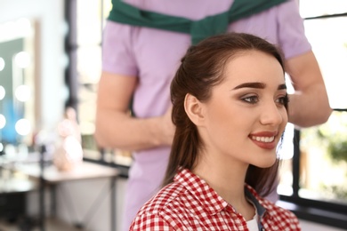 Photo of Professional hairdresser working with client in beauty salon