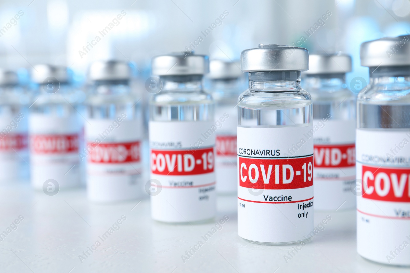 Photo of Glass vials with COVID-19 vaccine on light table