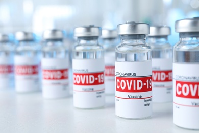 Glass vials with COVID-19 vaccine on light table