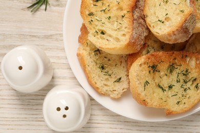 Photo of Tasty baguette with garlic and dill on white wooden table, flat lay