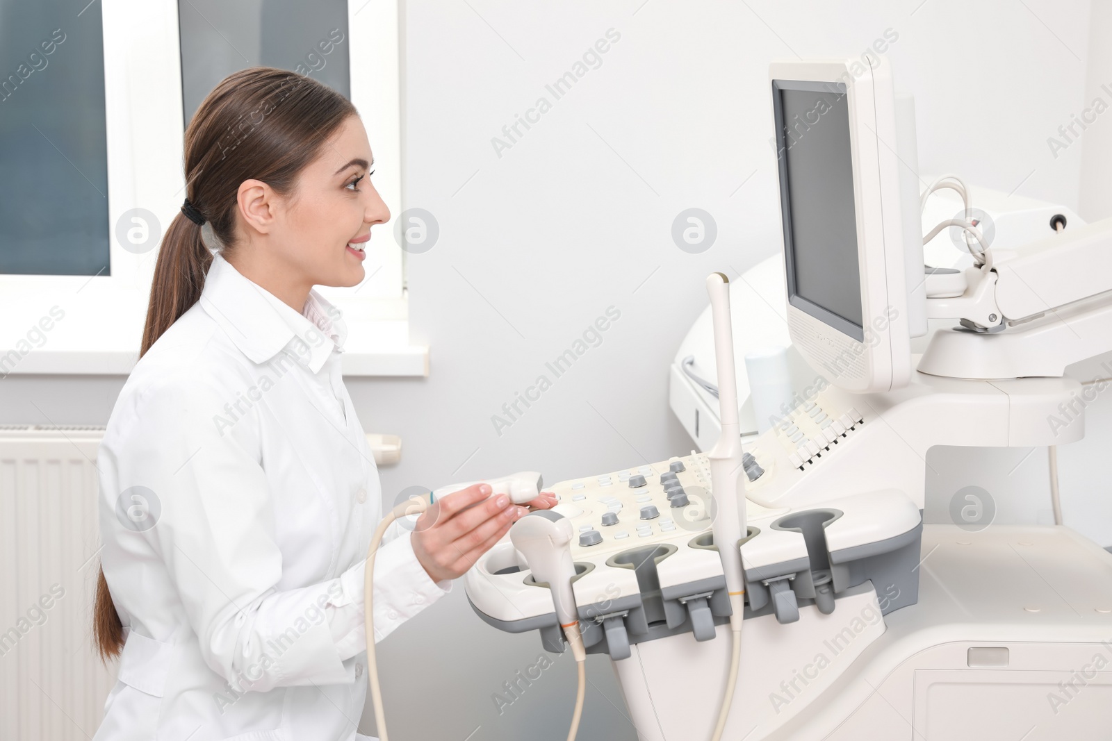 Photo of Professional sonographer using modern ultrasound machine in clinic