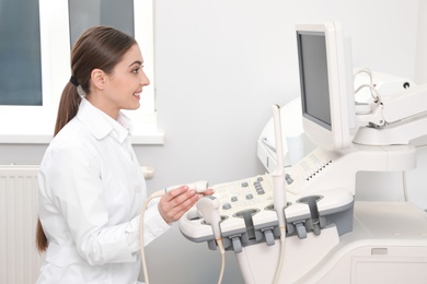 Professional sonographer using modern ultrasound machine in clinic