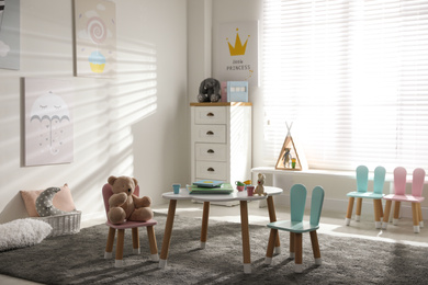 Small table and chairs with bunny ears in children's room interior