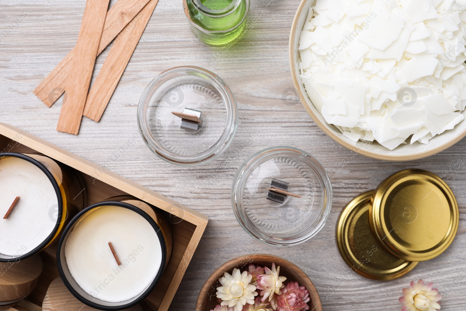 Photo of Flat lay composition with homemade candles and ingredients on light wooden background