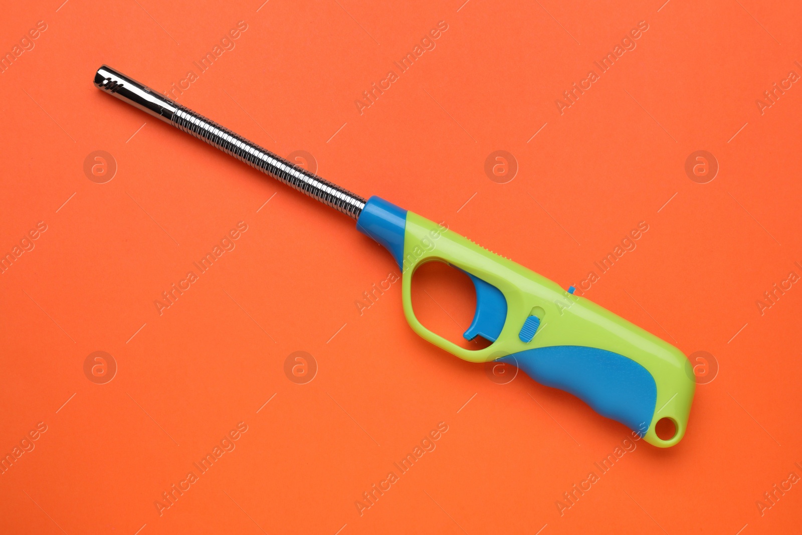 Photo of One gas lighter on orange background, top view