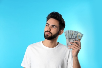Photo of Portrait of thoughtful young man with money on color background