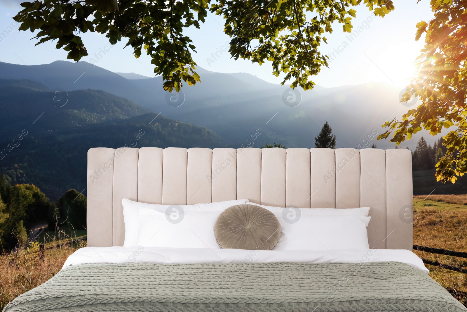 Image of Comfortable bed with soft pillows and picturesque view of mountains on background