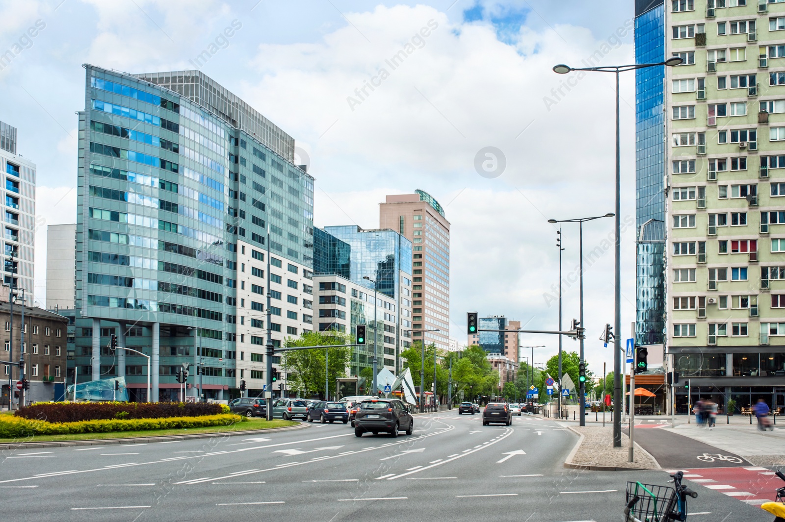 Photo of Road, cars and beautiful buildings on cloudy day in city