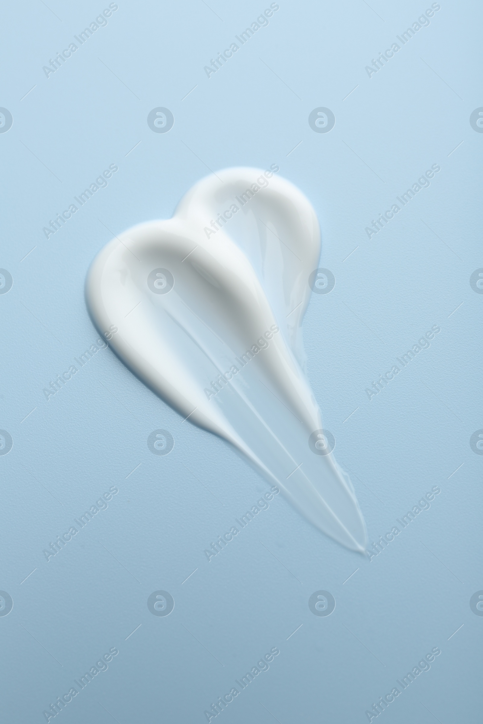 Photo of Sample of face cream on light blue background, top view