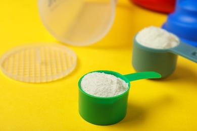 Photo of Measuring scoops with protein powder, shaker on table. Space for text