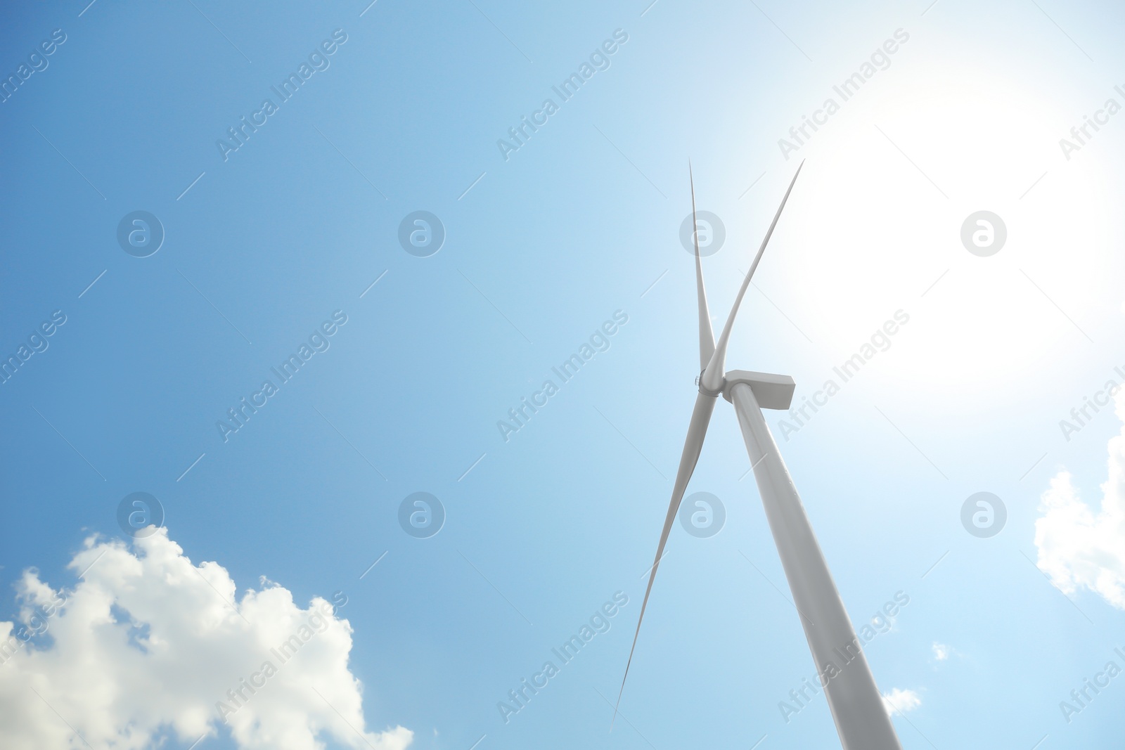 Photo of Modern wind turbine against blue sky, low angle view. Energy efficiency