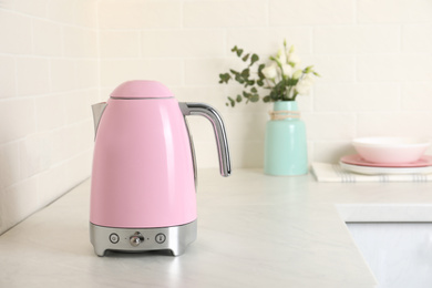 Photo of Modern electric kettle on counter in kitchen. Space for text