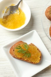 Photo of Slice of bread with pike caviar on white wooden table, flat lay