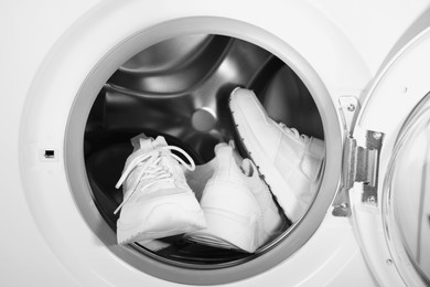 Stylish clean sneakers inside modern washing machine