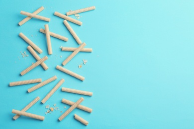 Photo of Flat lay composition with tasty wafer rolls on color background. Space for text