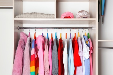 Photo of Wardrobe with stylish girl's clothes hanging on rack