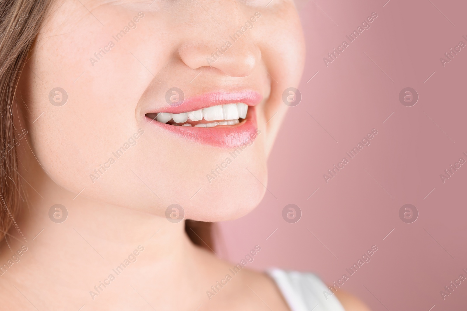 Photo of Young woman with beautiful smile on color background, closeup. Space for text