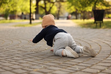 Learning to walk. Little baby crawling in park