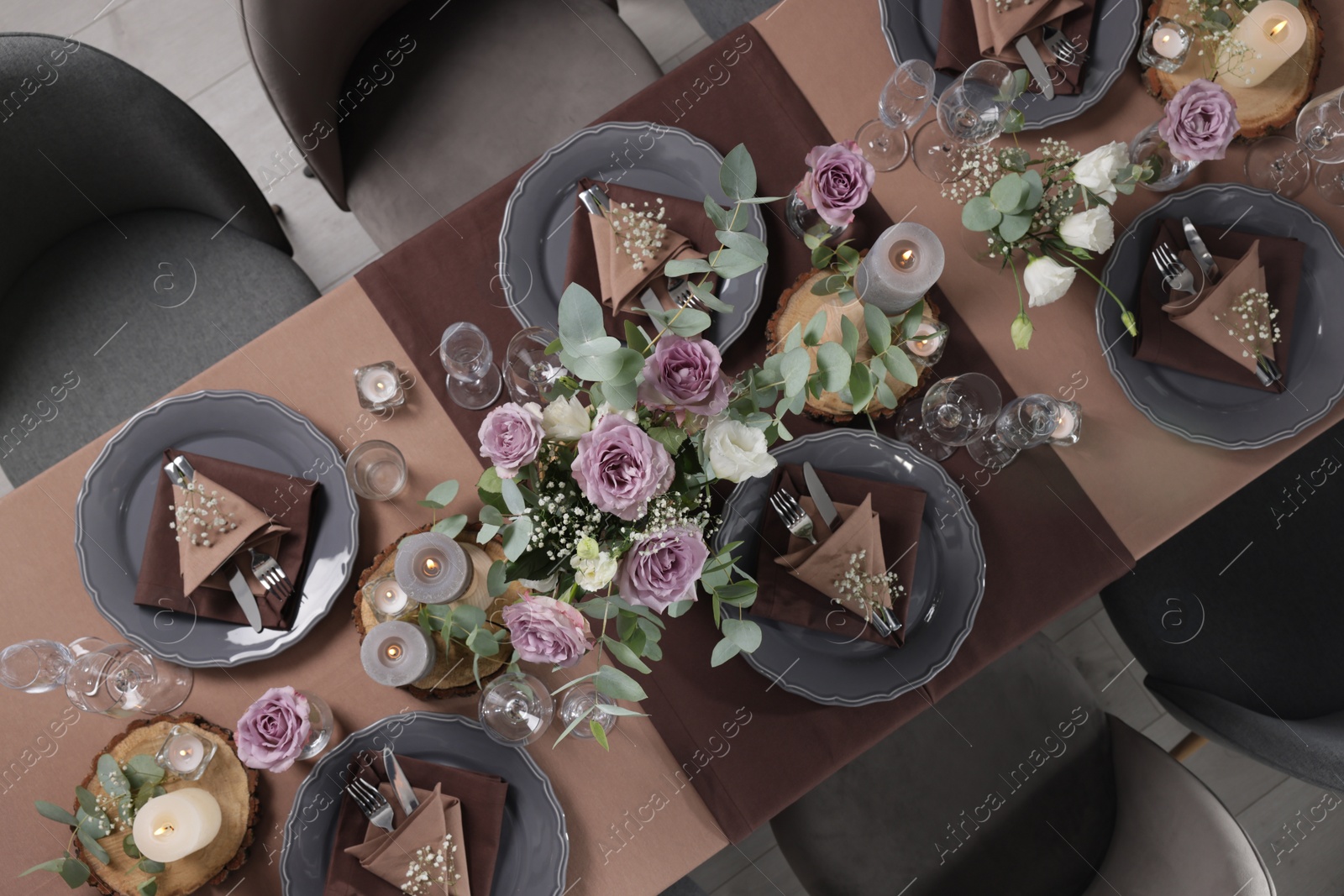 Photo of Elegant table setting with beautiful floral decor and burning candles, top view