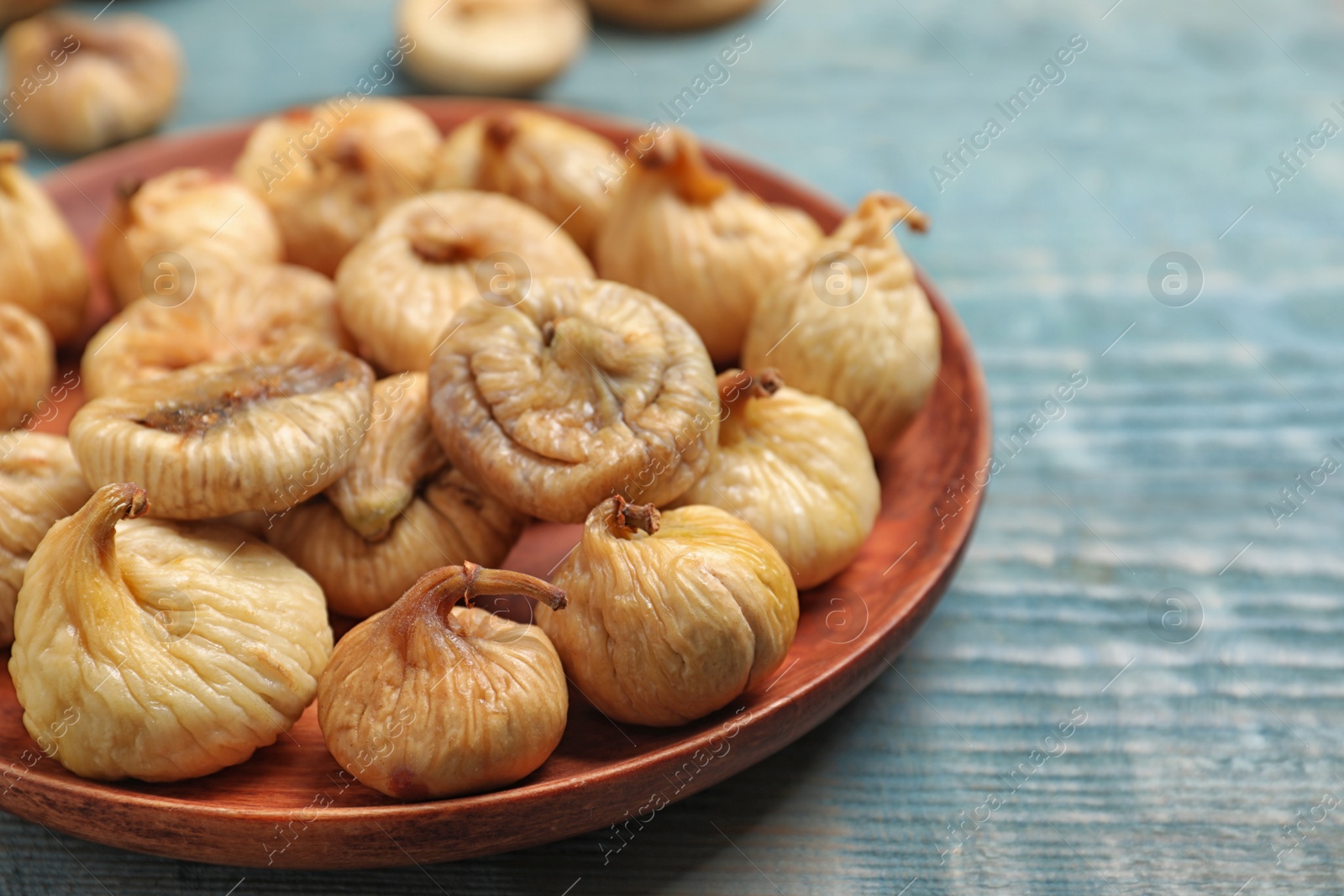 Photo of Tasty dried figs on light blue wooden table, closeup