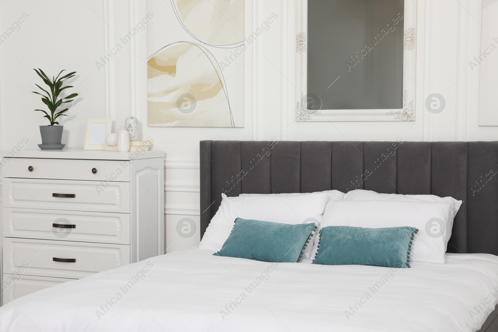 Photo of Large comfortable bed with cushions in bedroom. Interior design