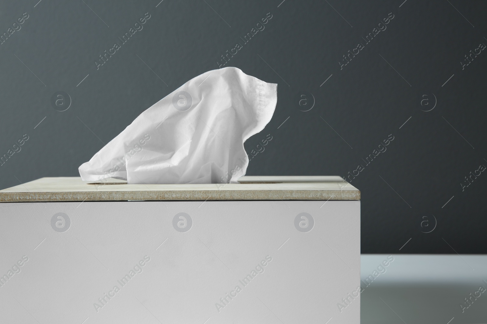 Photo of Holder with paper tissues on table, closeup