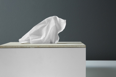 Photo of Holder with paper tissues on table, closeup