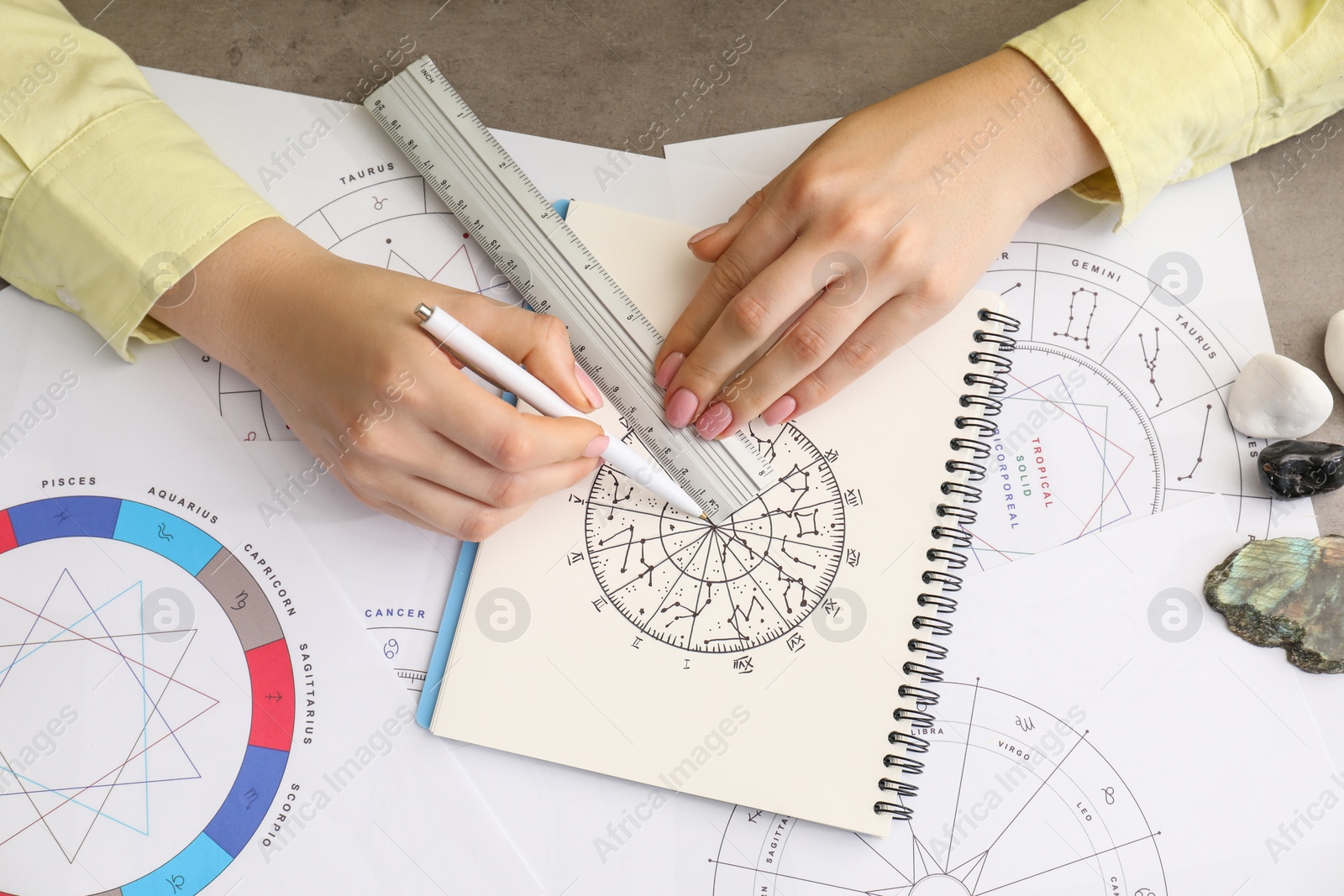 Photo of Astrologer using zodiac wheel for fate forecast at table, top view. Fortune telling