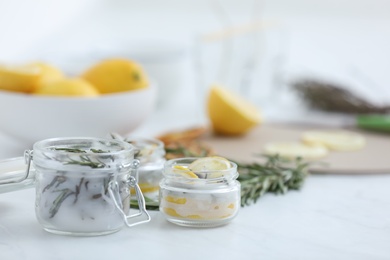 Photo of Natural homemade mosquito repellent candles and ingredients on white table. Space for text