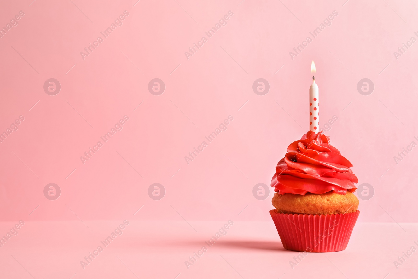 Photo of Delicious birthday cupcake with candle on color background