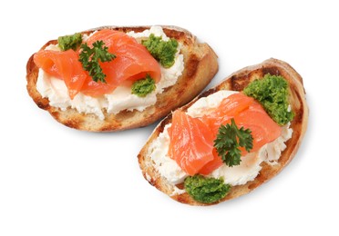 Photo of Delicious bruschettas with cream cheese, salmon and pesto sauce on white background, top view