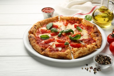 Delicious Margherita pizza and ingredients on white wooden table