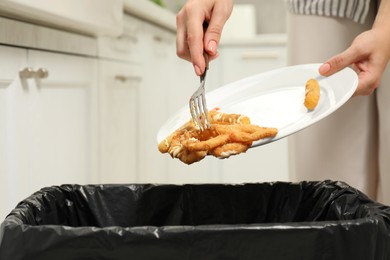 Photo of Woman throwing onion rings into bin indoors, closeup