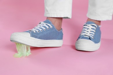 Photo of Person stepping into chewing gum on pink background, closeup