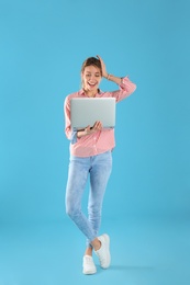Photo of Full length portrait of surprised young woman in casual outfit with laptop on color background