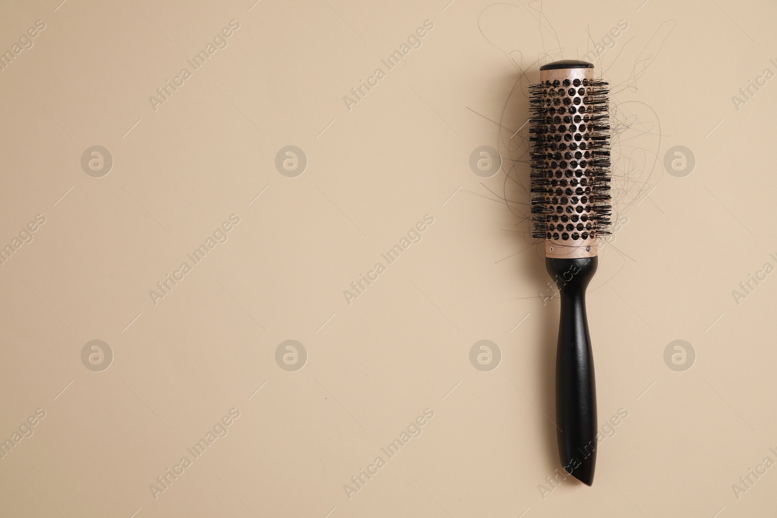 Photo of Professional brush with lost hair on beige background, top view. Space for text