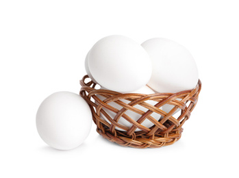 Photo of Chicken eggs in small wicker bowl isolated on white