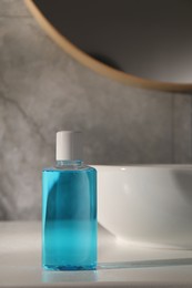 Photo of Bottle of mouthwash on light countertop in bathroom