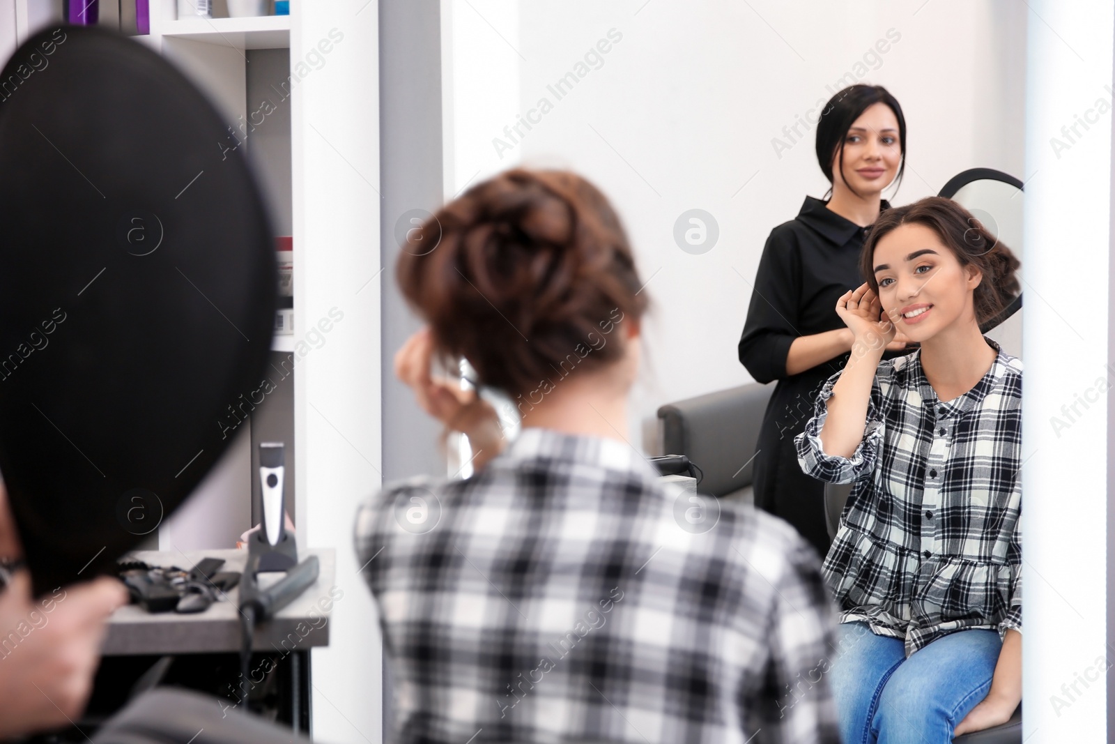 Photo of Professional female hairdresser working with client in salon