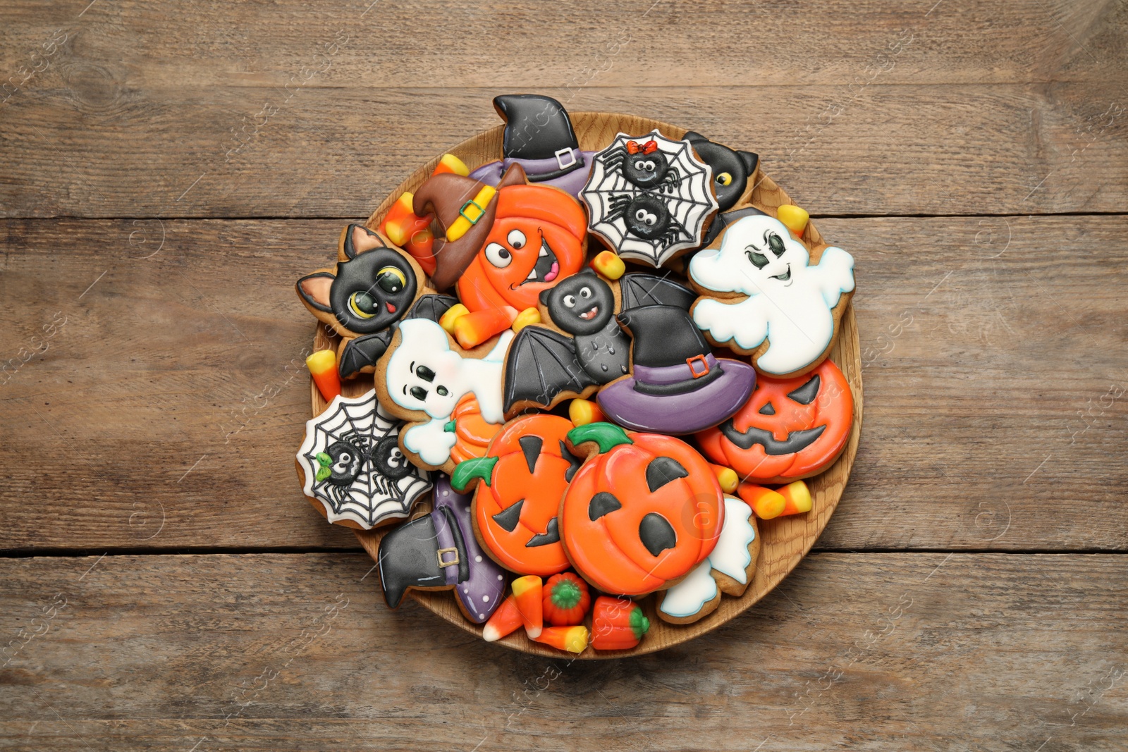 Photo of Tasty cookies and sweets for Halloween party on wooden table, top view