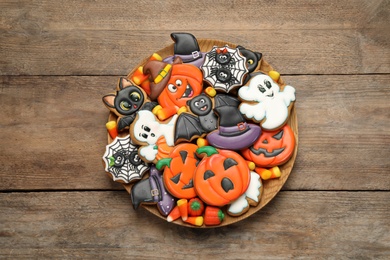 Tasty cookies and sweets for Halloween party on wooden table, top view