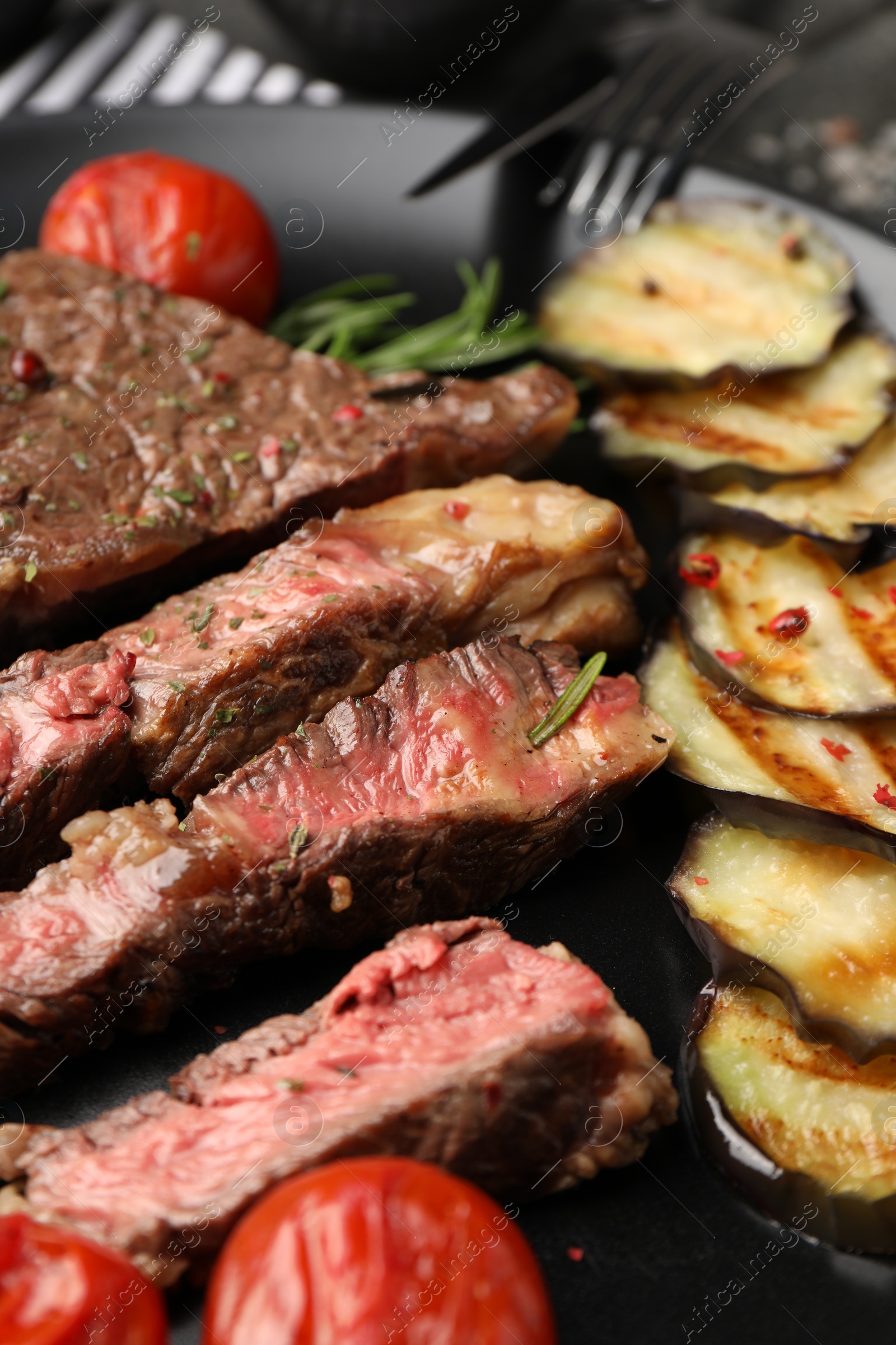 Photo of Delicious grilled beef steak with vegetables and spices on plate, closeup