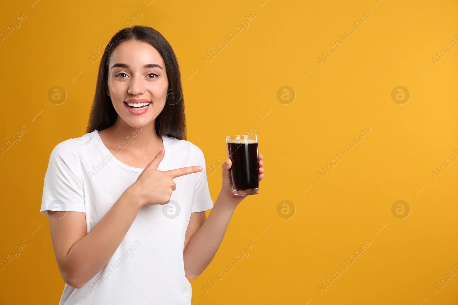 Photo of Beautiful woman with cold kvass on yellow background. Traditional Russian summer drink